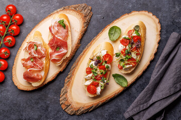Tasty antipasto toasts featuring classic caprese with mozzarella and tomatoes, and savory prosciutto with herbs