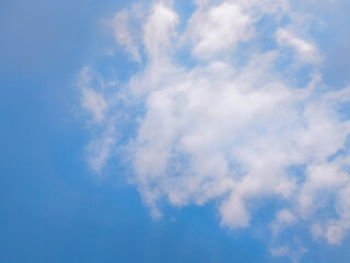 Clear Blue Sky with Soft White Clouds on a Sunny Day. Bright blue sky with gentle white clouds scattered across a sunny backdrop