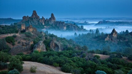 Ancient stone ruins majestically dominate a misty mountain peak, shrouded in clouds, as twilight casts a soft glow over the landscape