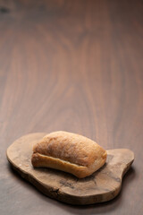 sliced ciabatta bun on wood board closeup