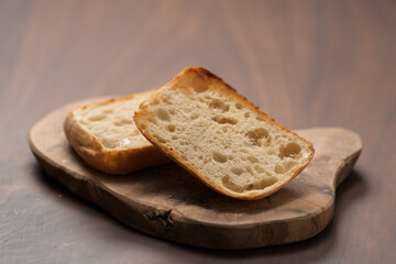 sliced ciabatta bun on wood board closeup