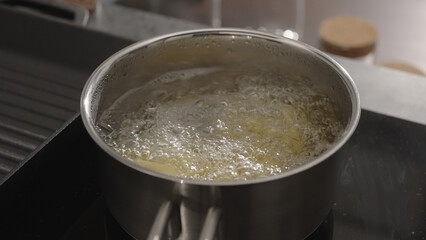 fettuccine boiling in saucepan with back light