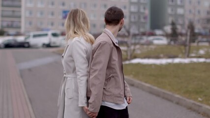 A heartwarming video shows a joyful couple walking hand in hand down a vibrant street, embodying romance in their smiles and gestures