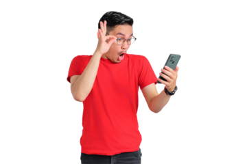 Shocked young Asian man looking at mobile phone screen reacting to online news with opened mouth isolated on transparent background