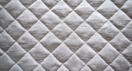 Fototapeta premium White quilted fabric texture creating diamond pattern background