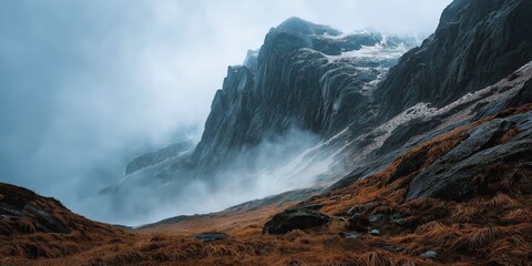 Misty Cliffside Mountain Rising Above Golden Grass Hillside in Autumn Light, Dramatic Landscape with Steep Rocky Slopes, Rugged Nature Scene Evoking Solitude, Wilderness, and Majestic Elevation