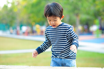 Fototapeta premium Happy adorable little 3 year boy running on green grass in morning park