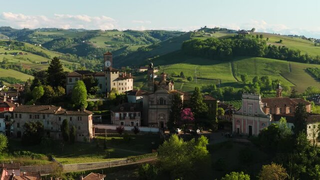 Neive Village And Catholic Church Overlooking The Green Mountains In Summer In Cuneo, Italy. - aerial shot