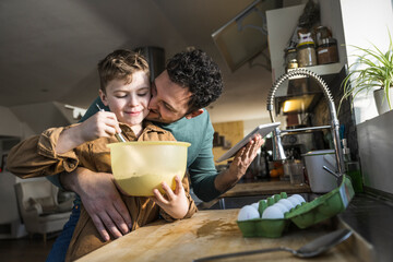 Father and son enjoying quality time cooking together in the kitchen