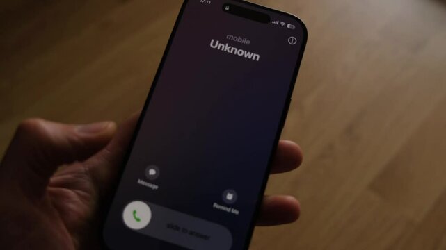 Fraud or fraudulent schemes. Close-up of a male hand holding a phone with an unexpected incoming call from an unknown