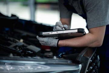 Close-up hand of Professional mechanic holding the tablet for maintenance checklist vehicle, Software for manager check to repair