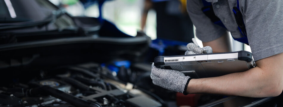 Panoramic Close-up hand of Professional mechanic holding the tablet for maintenance checklist vehicle, Software for manager check to repair