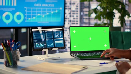 Young general manager using green screen on laptop and evaluating performance metrics for her staff, conducting a planning session. African american CEO shows leadership skills. Camera A.