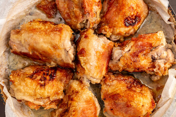 Top view of perfectly fried chicken thighs with heavily textured crust, glistening with oil in frying pan.
