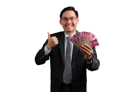 Handsome Asian businessman in suit holding money and showing thumbs up, isolated on transparent background