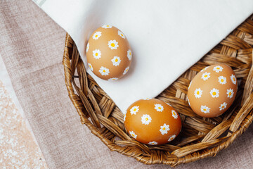 Set of Easter eggs with hand-painted daisy flowers on fabric. Artistic spring decoration in soft natural light...