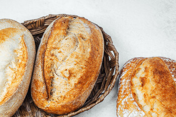 Freshly baked artisan bread loaves in a wicker basket on a kitchen countertop