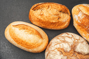 Freshly baked artisanal bread loaves on a dark stone surface