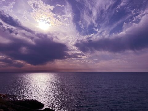 Evening glittering sea and sunset cloudy sky