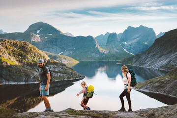 Norway family travel lifestyle active tour parents and child hiking in Lofoten Islands exploring mountains together summer vacations trip, mother father and kid on adventure camping tour at the lake