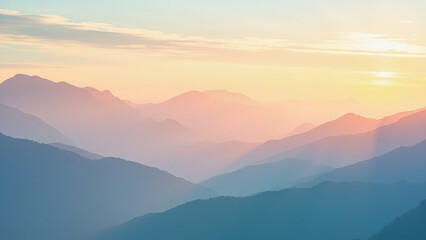 Serene mountain range silhouettes at sunrise or sunset with soft hues