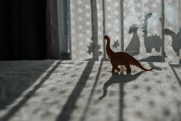 Nursery room with dinosaur shadows on curtain.