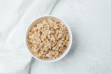 Warm bowl of oatmeal served on a clean kitchen countertop in the morning
