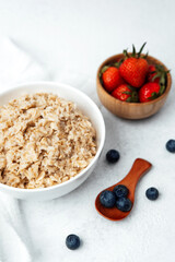 Healthy breakfast featuring oatmeal, fresh strawberries, and blueberries