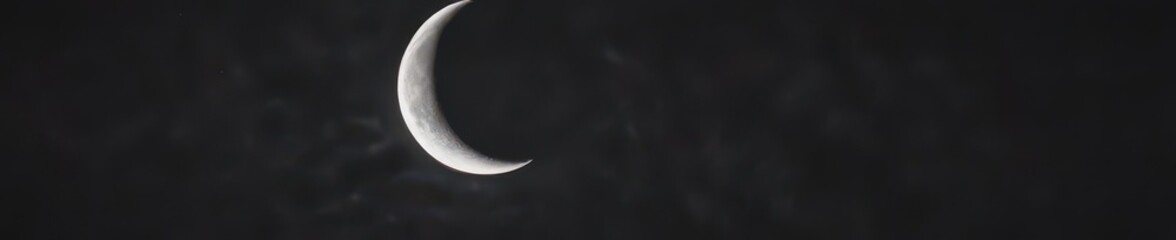 Bright crescent moon dominates inky black night sky , cosmos, peaceful, dark blue