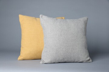 Two soft decorative pillows on grey background