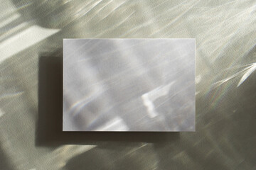 Empty paper card with sunlight shadows on glare green background. Natural abstract aesthetic mockup with caustic effects for design and presentation.