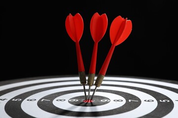 Targeting. Dart board with arrows on black background, closeup
