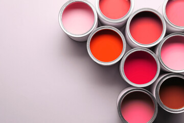 Cans with paint in shades of red on white background, top view. Space for text