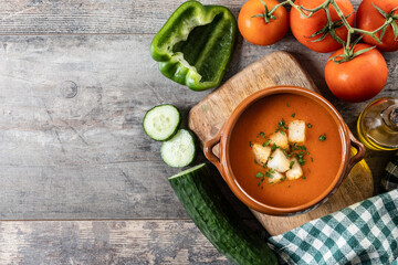 Traditional Spanish Gazpacho soup in bowl on wooden table. Top view. Copy space