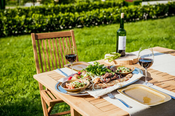 Delicious Grilled Steak meat with Sides BBQ Lunch with wine on nature in park by summer.