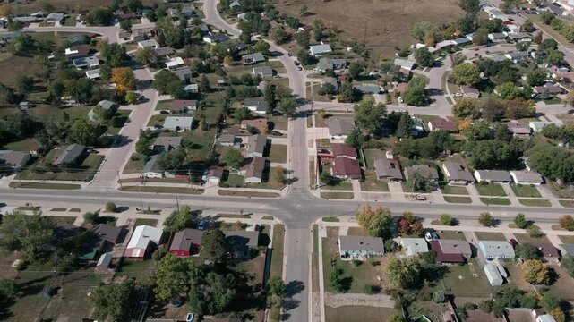 A drone flying backwards and panning the camera up revealing homes with hills in the background in Rapid City, South Dakota