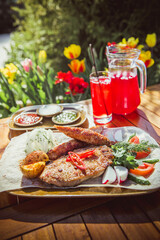 Delicious Grilled Steak with Sides BBQ Lunch with red juice on nature by summer.