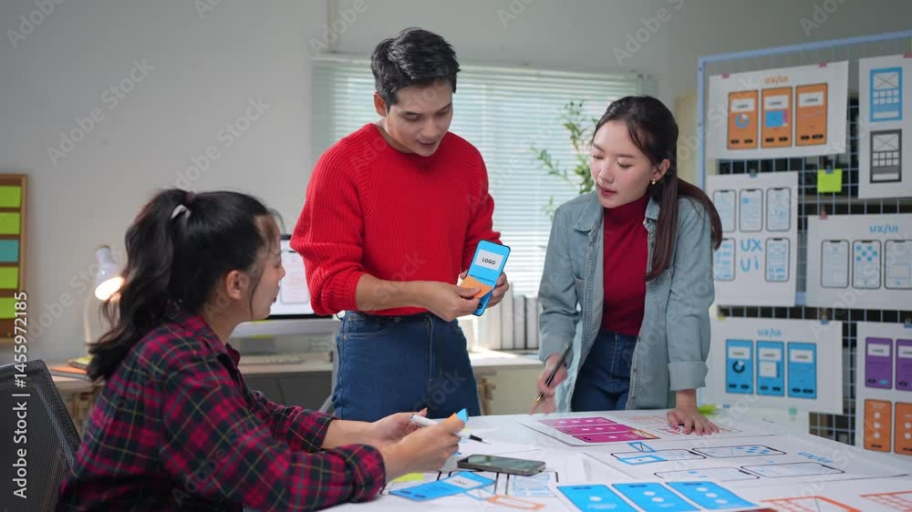 Wall mural creative asian web design team collaborating on mobile application development, analyzing project de