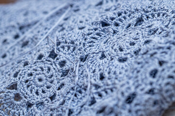 Close up of hands of unrecognizable woman knitting handmade clothes with spokes using  wool yarn....
