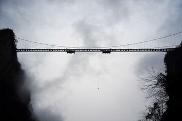 Fototapeta premium Bungee Jump from a Bridge Under Cloudy Sky