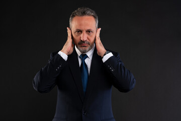 Businessman covering ears with hands.