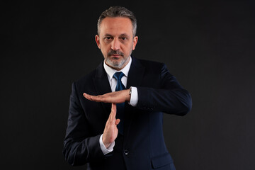 Businessman making time out hand gesture.