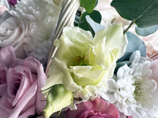 Elegant arrangement of pastel roses, white chrysanthemums, and delicate green lisianthus with foliage