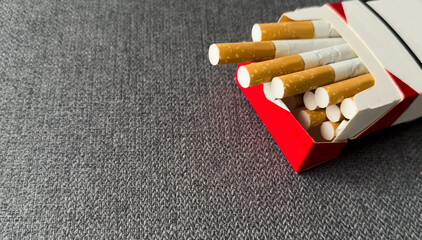 Cigarettes in a pack. Yellow filter. Harm to health. Bad habit. A pack of cigarettes on the table. open pack of cigarettes.