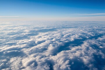 Breathtaking aerial perspective of a vast expanse of fluffy white clouds creating a mesmerizing scene under a clear blue sky