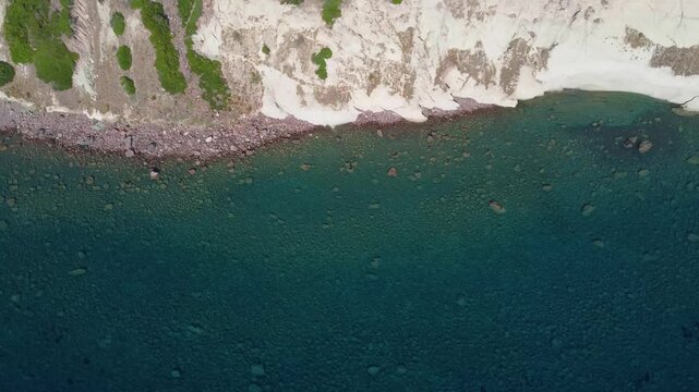 Top view of an empty and rocky coastline with cliffs and transparent waters in Grifone Nature Reserve on the west of Sardinia, Italy