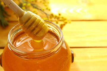 Honey dripping and glass jar full of honey                               