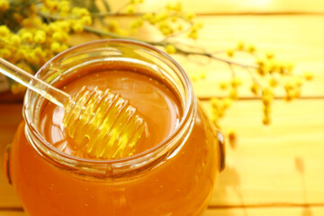 Honey dripping and glass jar full of honey                               