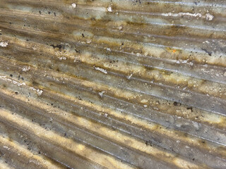 Close up of weathered and corroded fluted metal plate in brass gold paint color, and in sunburst pattern. Seamless metallic gold metal plate color. Graphic background texture.