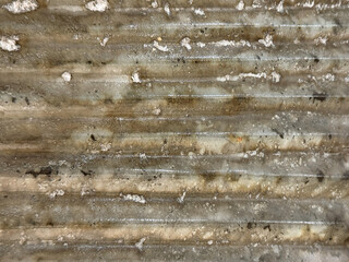 Close up of weathered and corroded fluted metal plate in brass gold paint color, and in sunburst pattern. Seamless metallic gold metal plate color. Graphic background texture.